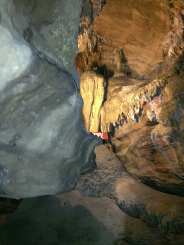 Cave passage with stalactites and tour signage
