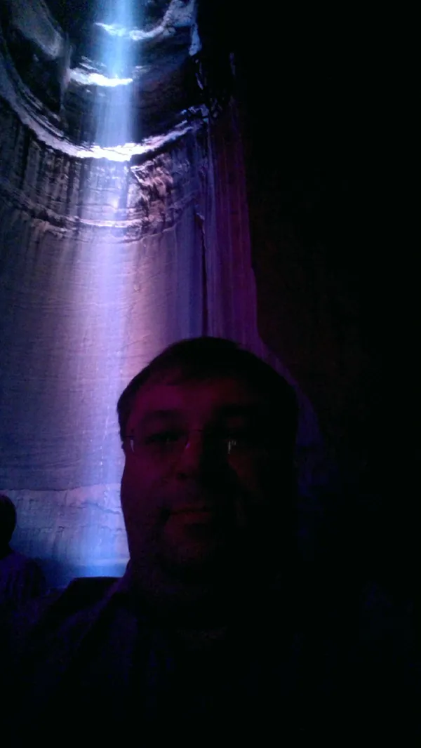Selfie in front of Ruby Falls with blue-purple light illuminating the cave