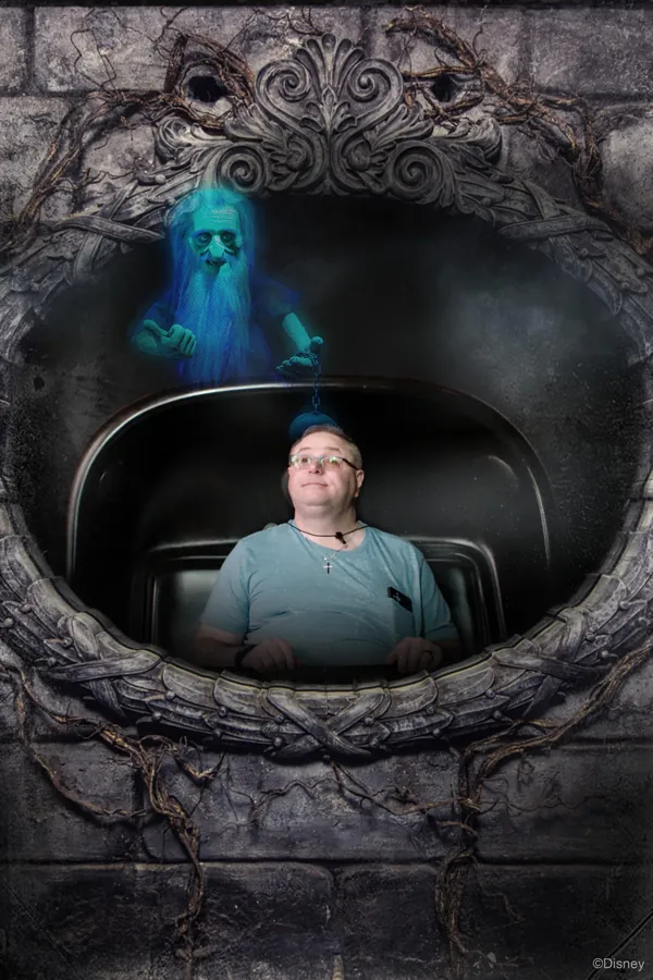 Haunted Mansion ride photo with a glowing blue ghost wizard appearing above the doom buggy